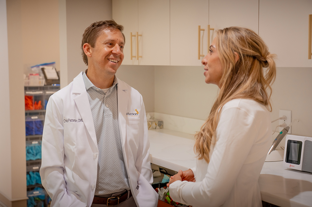 Dr. Chip Patterson Consulting with Staff at Patterson & Co Dental Care Dr. Chip Patterson talking with a team member in a Hoschton, GA dental treatment room